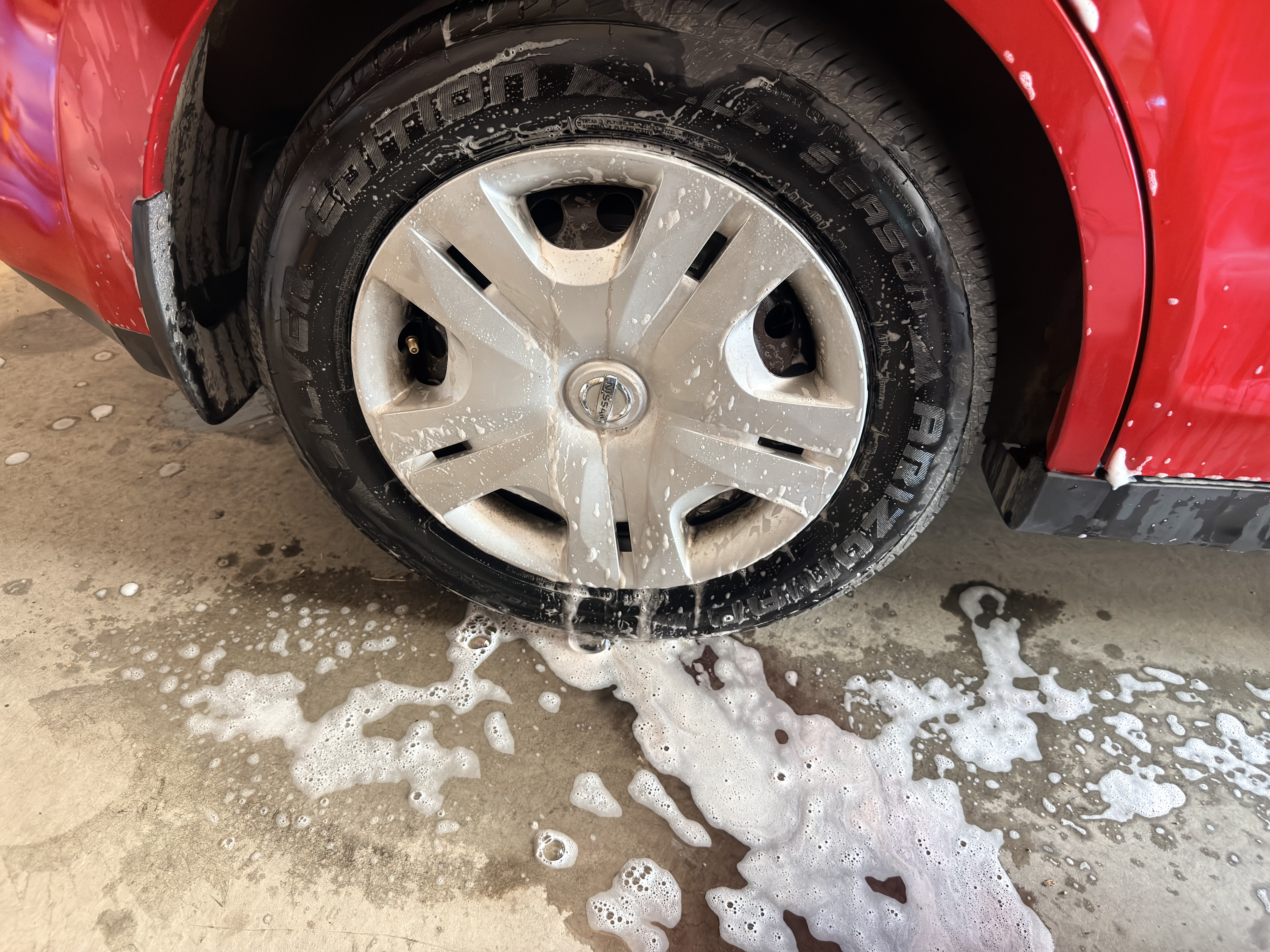 Nissan Versa wheel being washed - soap and water removing dirt