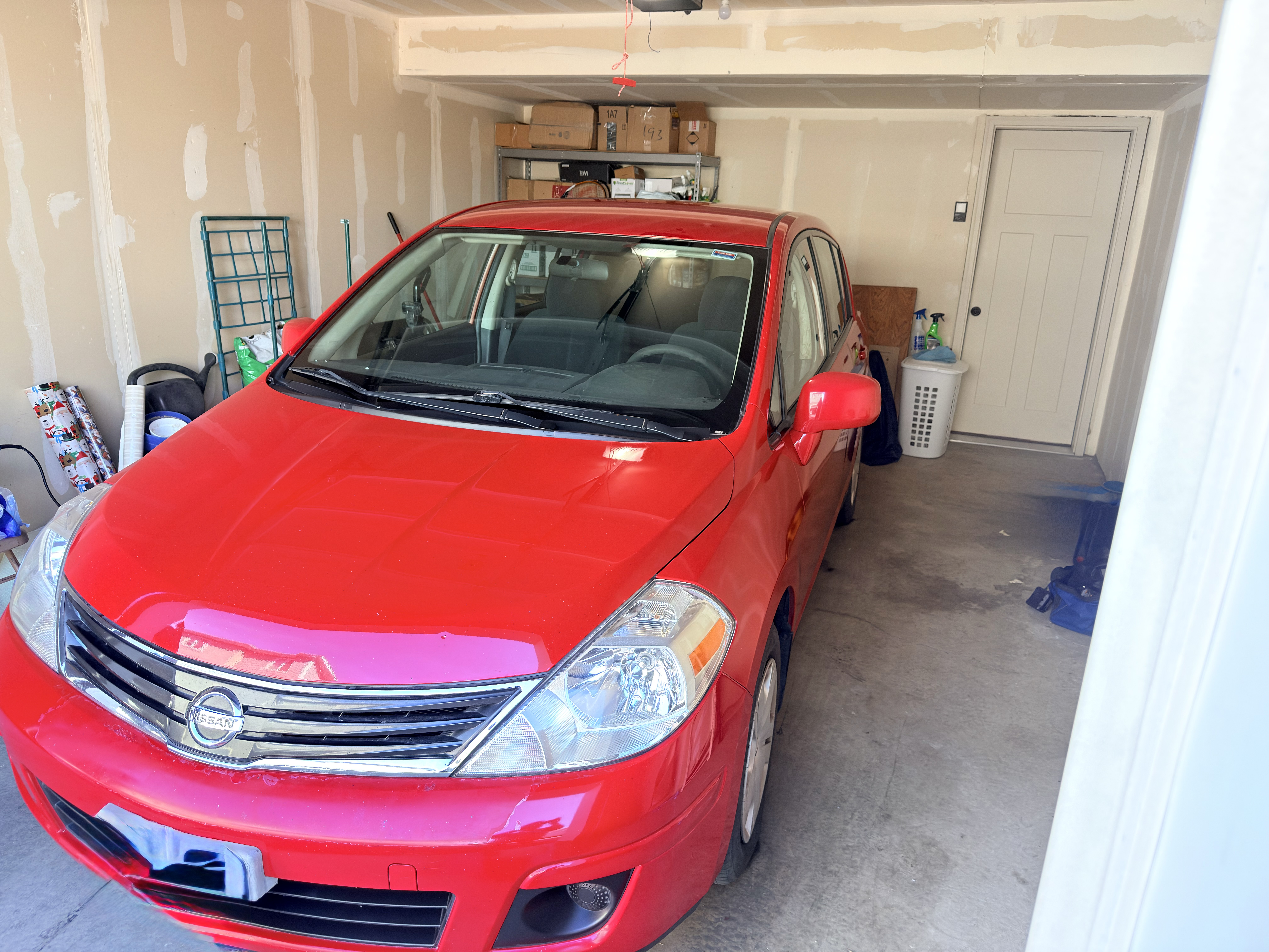 Red Nissan Versa after basic wash - clean front three-quarter view